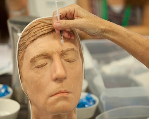 A doctor practising cosmetic injections on a mannequin